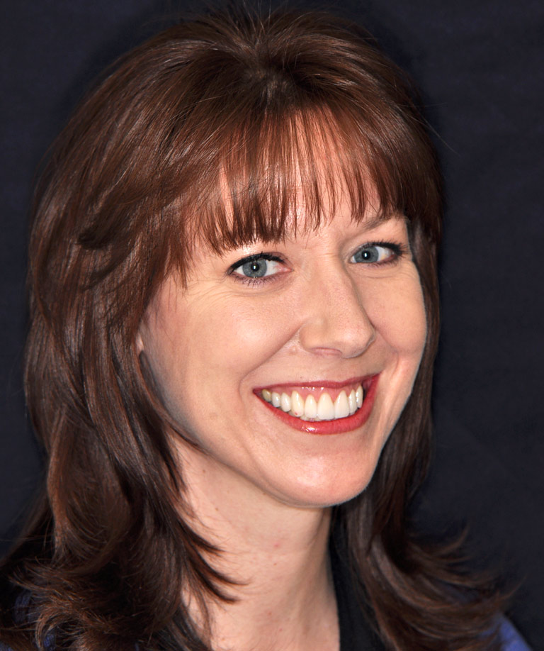 Headshot photo of brunette woman with bangs smiling showing smile makeover results from Weiss