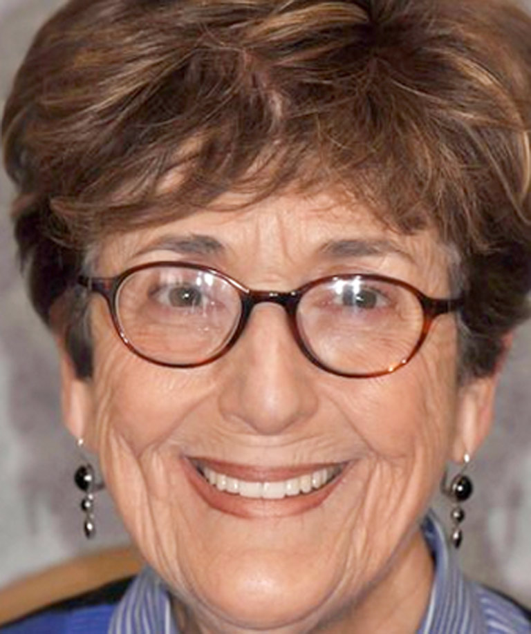 Headshot photo of older woman with glasses smiling showing smile makeover results from Weiss